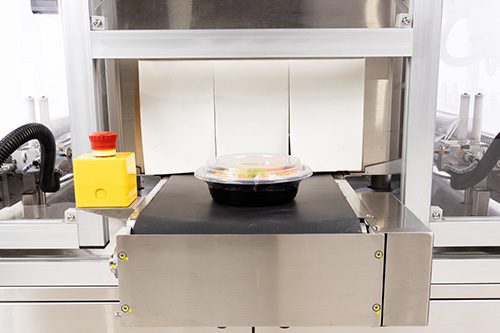 Vegetable container exiting the AutoBandit electric shrink tunnel